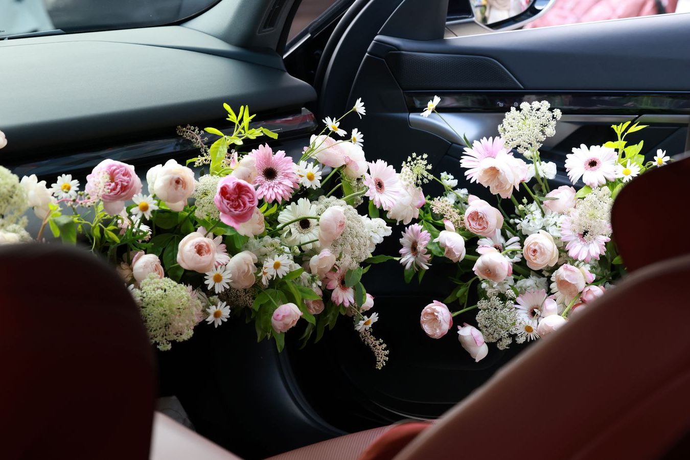 White wedding ribbon on a black luxury car outside a church